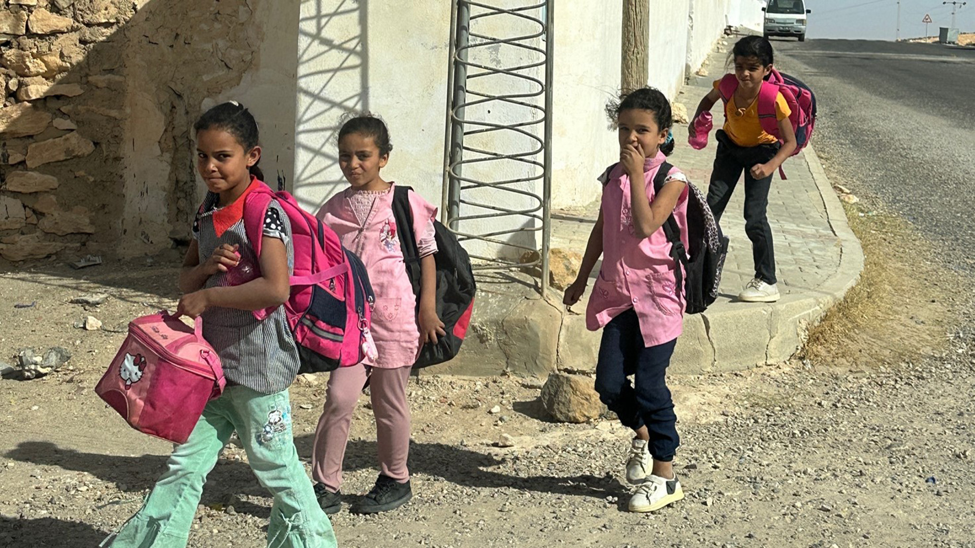 Bambini per strada che vanno a scuola